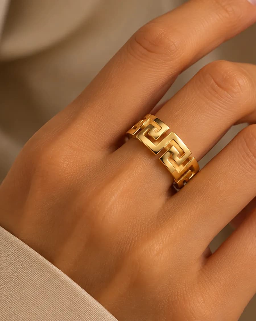 The Meander ring, a wide band of pierced Greek key, worn on a hand